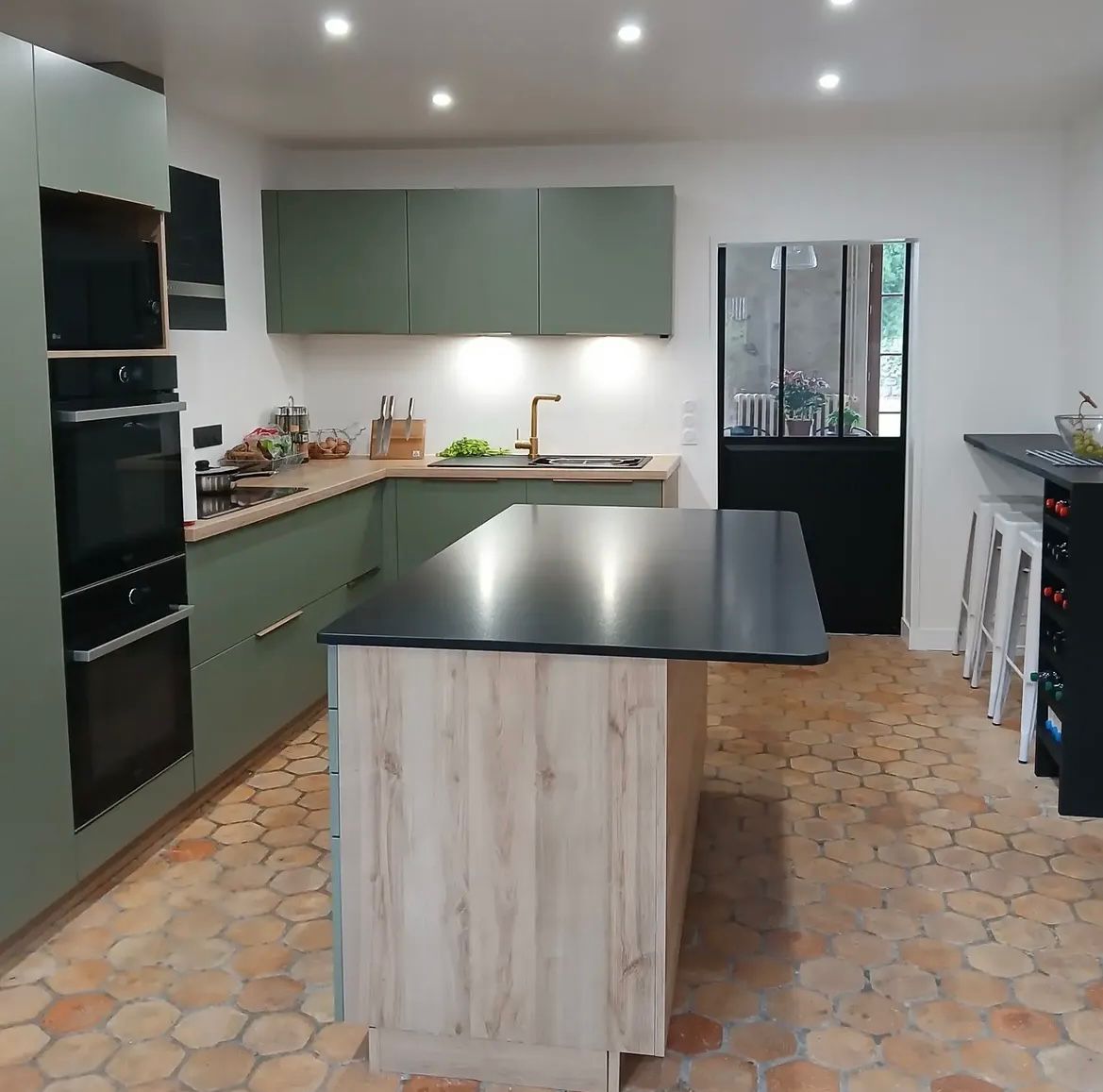 Cuisine verte avec îlot central et verrière